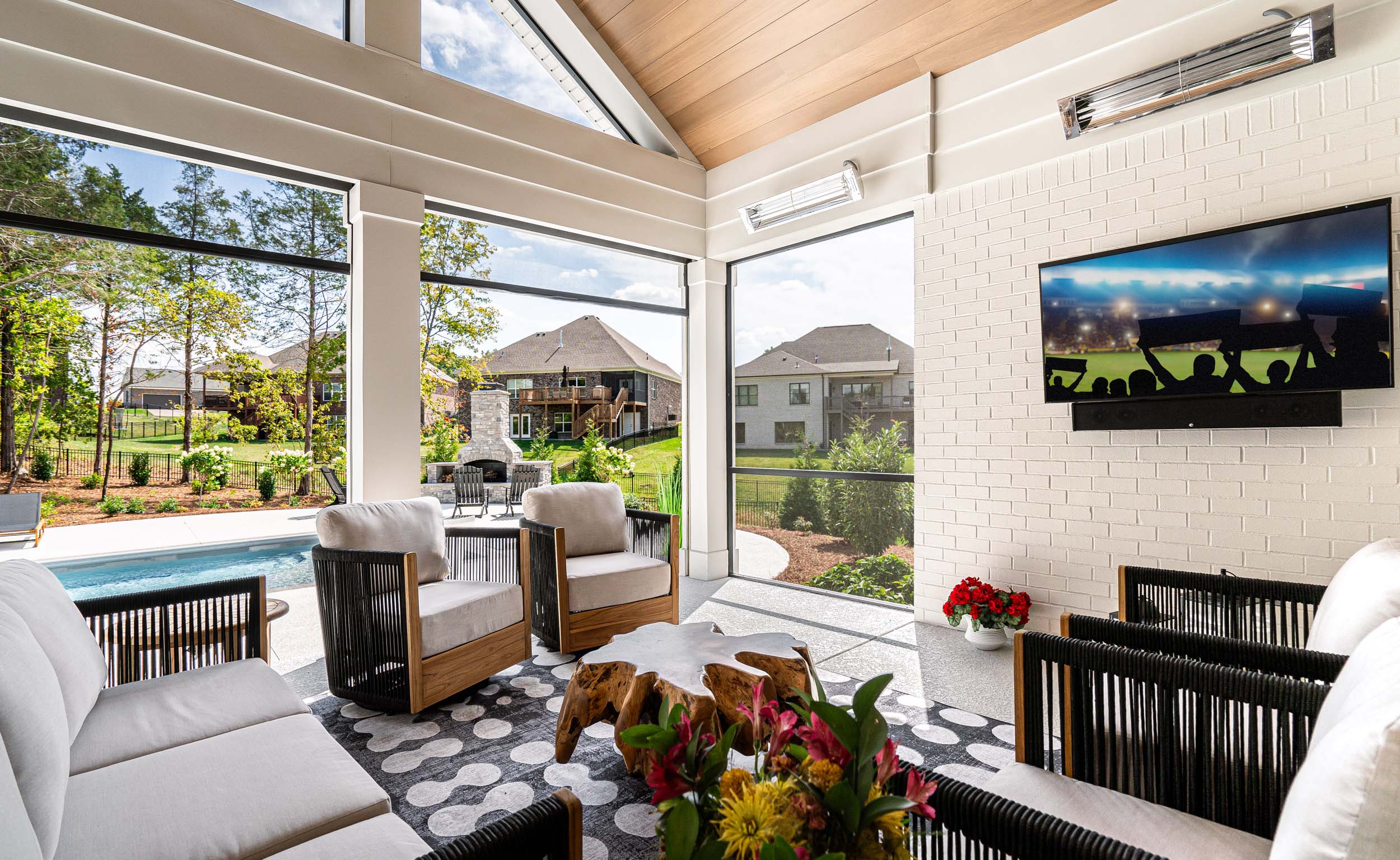 home with a three season room with motorized bug screens and outdoor entertainment