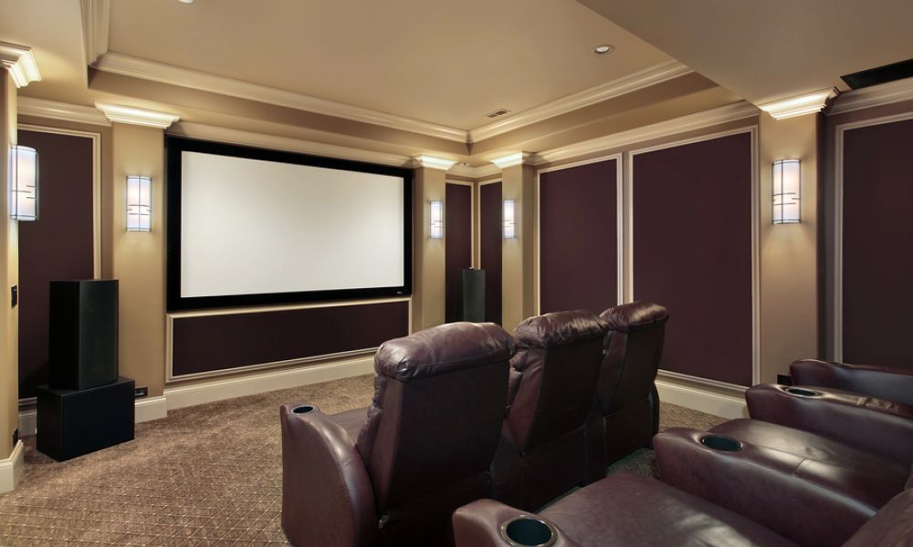 <span class="uk-h4">Home theater room with a large projector screen, leather recliners, and elegant wall sconces.</span>