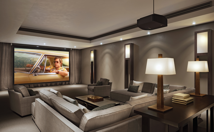 A luxury media room with a large screen, hidden audio, and expansive sofa seating.